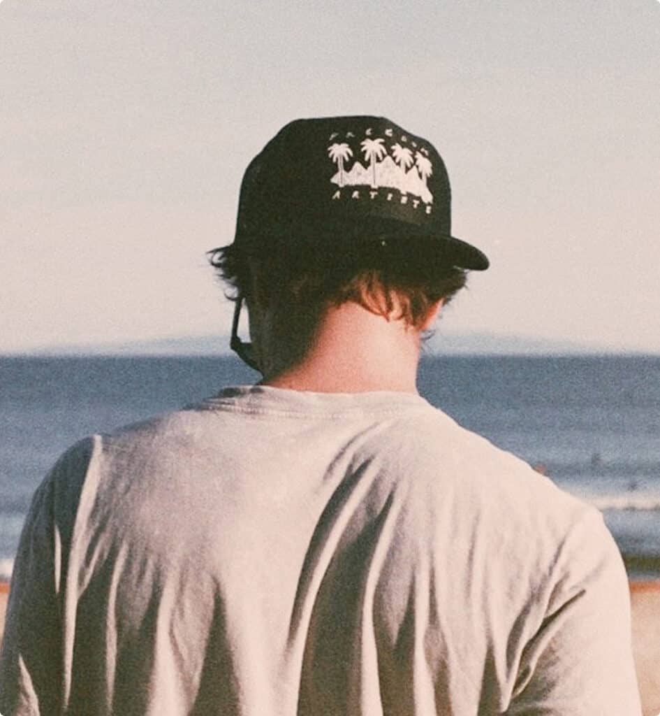 Man wearing a custom printed trucker hat at the beach