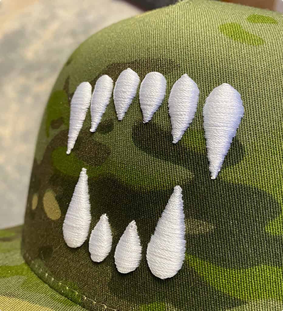 White 3D puff embroidery on a camo trucker hat