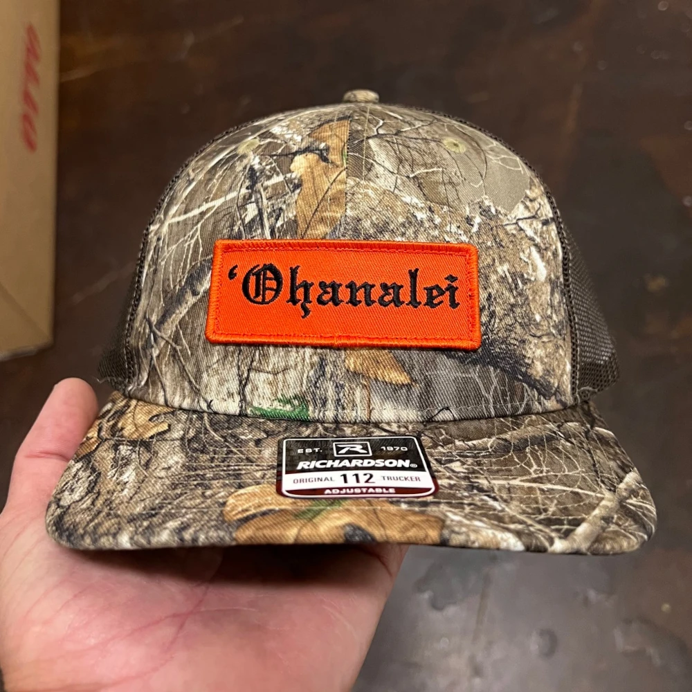 Realtree camo Richardson 112 trucker hat with embroidered orange rectangle woven patch