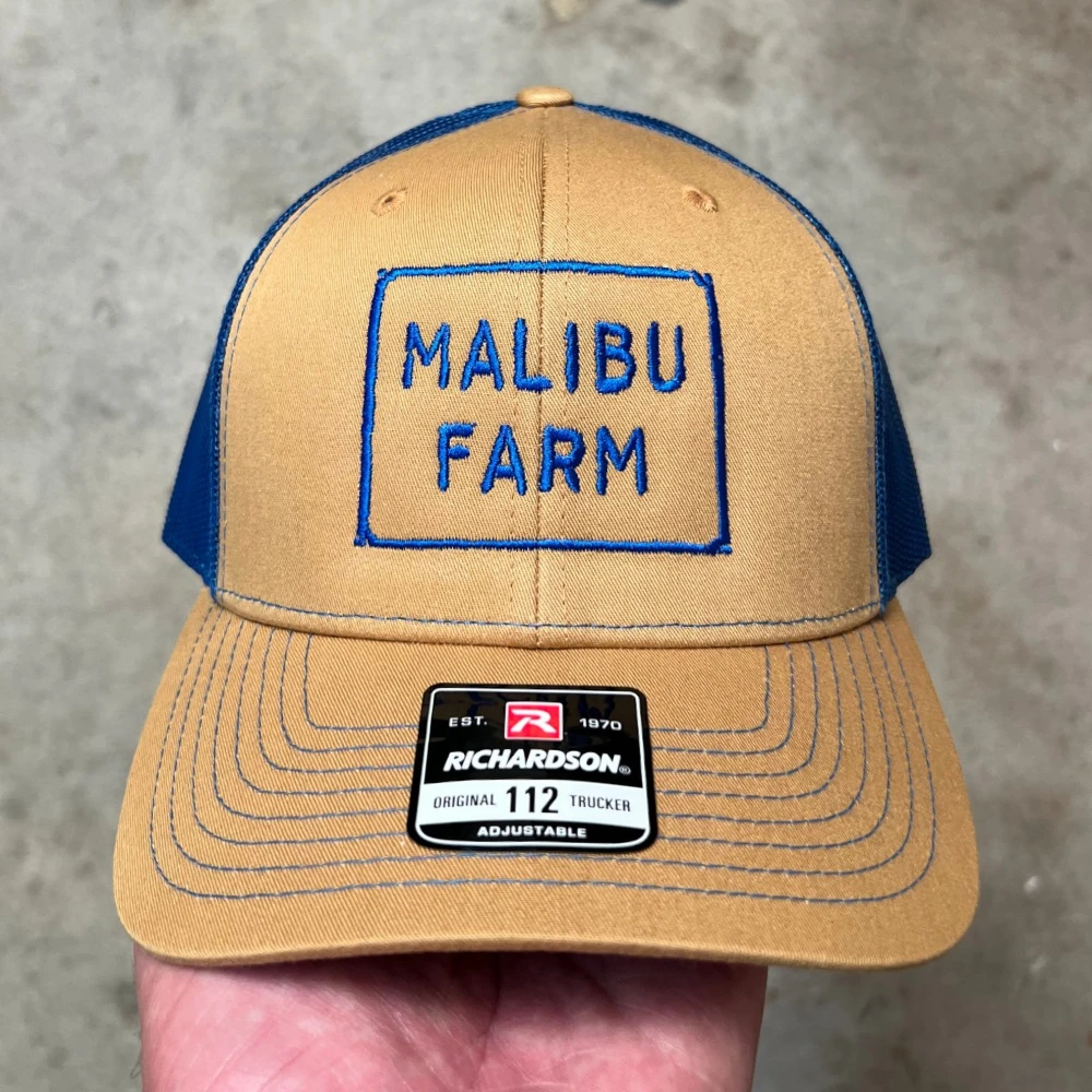Tan and navy Richardson 112 trucker hat with embroidered box logo