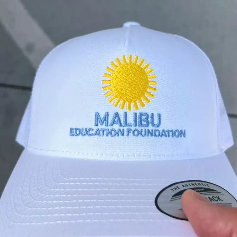 Multicolor sun logo embroidered on a white trucker hat