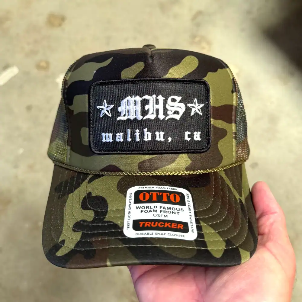 Camo Otto Cap foam front trucker hat with black embroidered rectangle patch