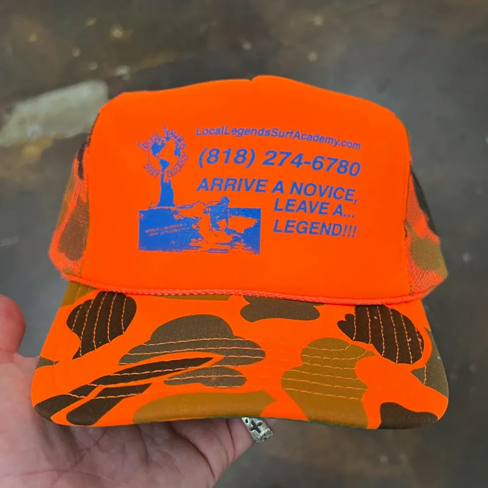 Neon orange and camo Otto Cap foam front trucker hat with blue printed logo